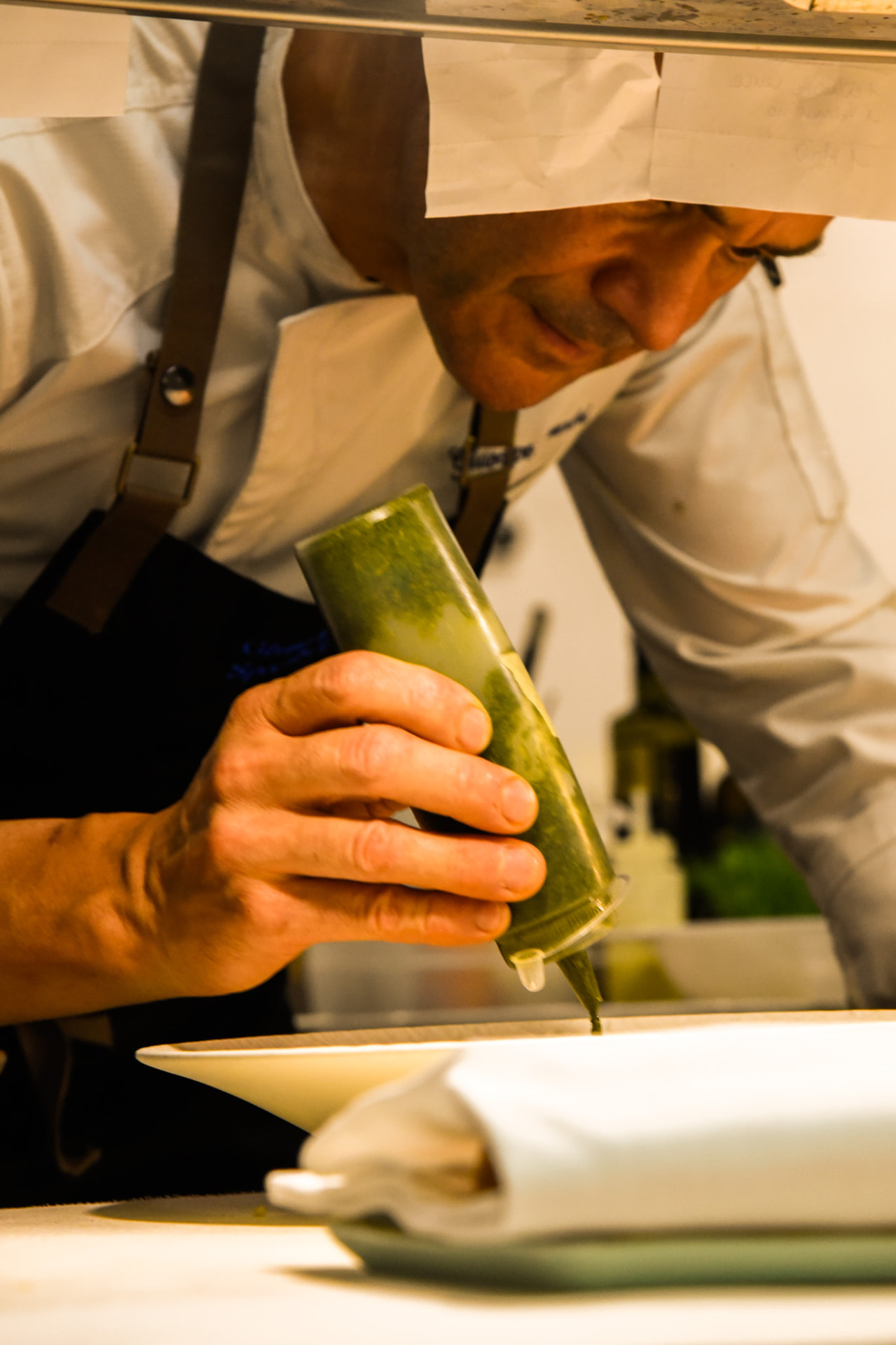 Lo chef di Gourmet Corallia rifinisce un piatto in cucina