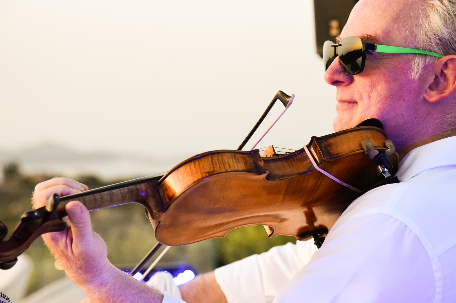 Violinista si esibisce dal vivo al tramonto durante un evento di Corallia Sound