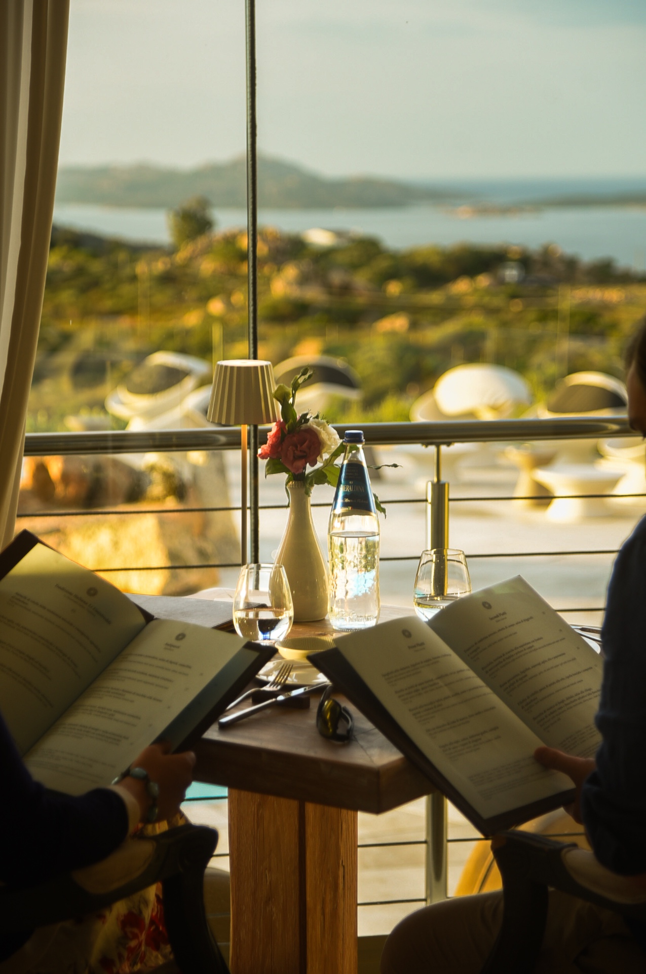 Ospiti sfogliano il menu con vista sull'arcipelago di La Maddalena